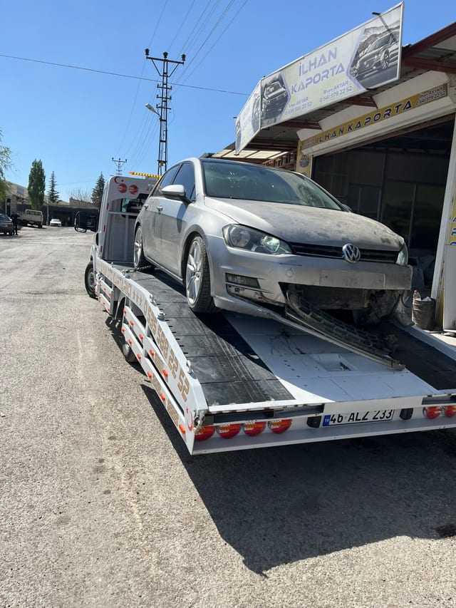 İş yeri önünde çekici platformuna yüklenmiş gri otomobil